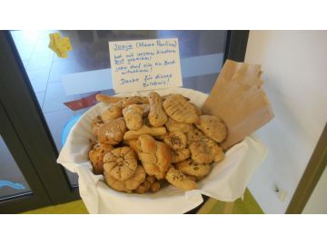 Eine Kostprobe für zu Hause, Foto von Ingrid VordermaierBrot backen im Kindergarten Sonja Haider, eine Mama aus dem Gesundheitsteam, erklärte sich bereit mit unseren Kindern Brot zu backen. Sie brachte ihre Küchenmaschine, die Getreidemühle, Getreidekörner, Mehl, Wasser, Germ, Salz, verschiedene Gewürze und Körner zum Bestreuen mit. In unserem Speiseraum wurde ein Brotbackstube vorbereitet, in der die Kinder Getreide mahlen, bei der Zubereitung des Brotteigs helfen durften und schließlich selber ein Brotstück formen konnten, das in unserer pädagogischen Küche gebacken wurde. Es war nicht nur bewundernswert wie viele fleißige Hände hier am Werk waren, sondern auch welch kunstvolle Gebäckstücke hergestellt wurden. Beim Eingang unseres Hauses wurde ein großer Korb mit den Gebäckstücken aufgestellt und jedes Kind durfte sich beim Nachhause gehen eines mitnehmen. Ein Erlebnis für Groß und Klein! Ein besonders Danke für Dein Engagement Sonja!